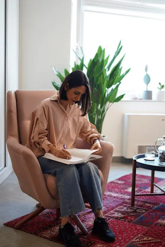 Ghazal writing notes in an armchair