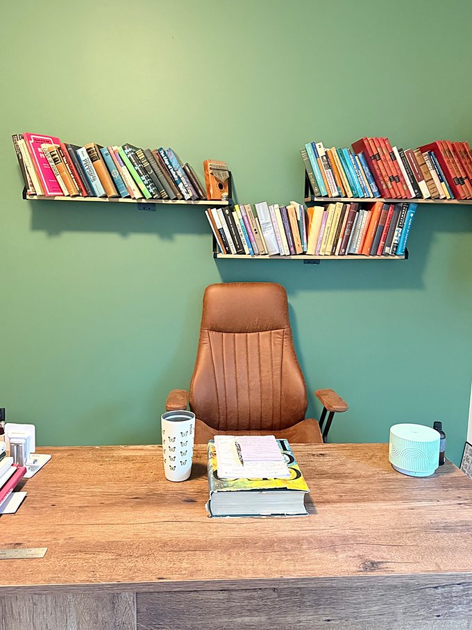 Ghazal's office — green wall, bookshelves and a leather chair